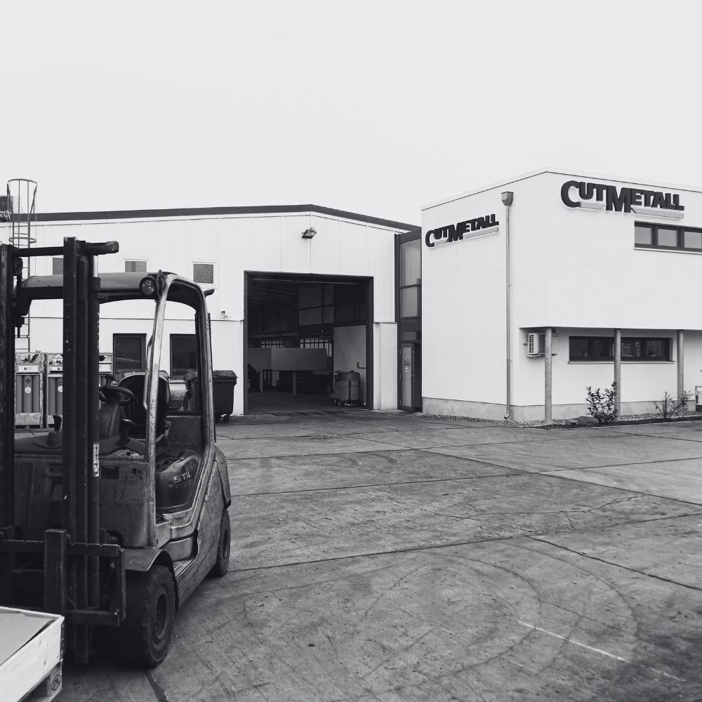 Logistikbereich von CUTMETALL mit Gabelstapler und Produktionshalle – industrielle Abläufe im Ersatzteilgeschäft für Recyclinganlagen