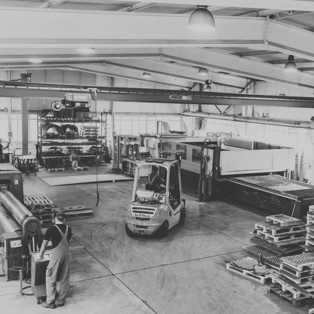 Produktionshalle von CUTMETALL mit Gabelstapler, Laserschneidanlage und gestapelten Siebplatten – Fertigung von Ersatzteilen für Recyclinganlagen