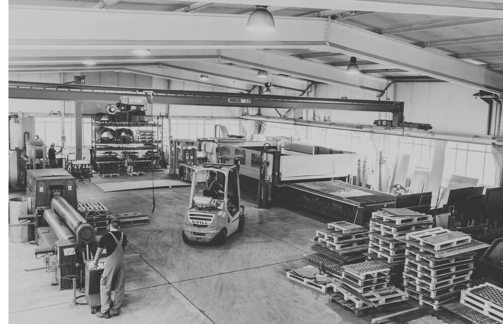 CUTMETALL production hall with forklift, laser cutting system and stacked screen plates – manufacturing spare parts for recycling plants