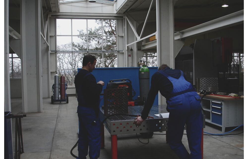 Techniciens de CUTMETALL en train de traiter un support de tamis perforé pour machines de recyclage sur une table de soudage
