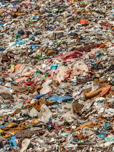 Der linke Ausschnitt eines Bildes. Es zeigt einen Haufen von Plastikmüll, bestehend aus Flaschen, Verpackungen und Folien, geeignet als Material für Ersatzbrennstoffe.