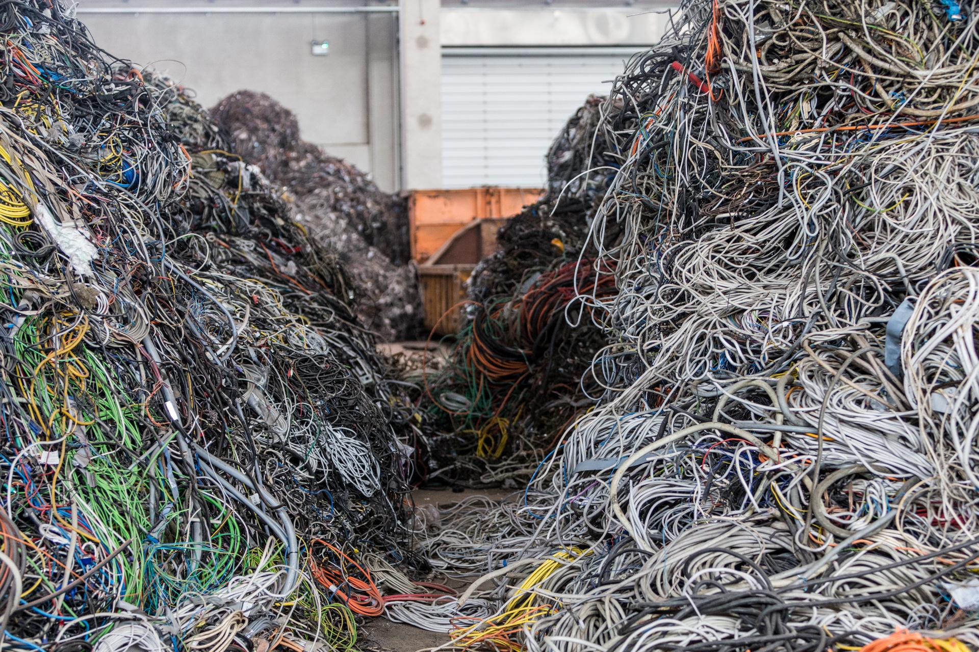 Vue de deux tas de déchets mélangés et colorés issus du recyclage des appareils électriques et des câbles.