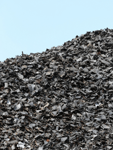 A pile of shredded tyres against a light blue background. The image is divided into three parts—this is the left section.