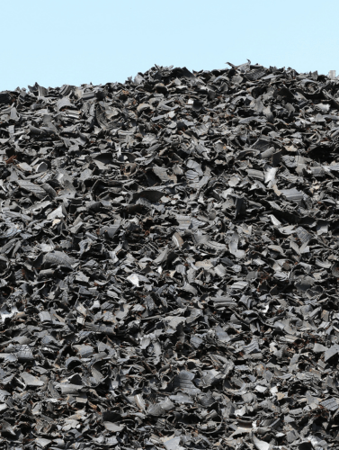 A pile of shredded tyres against a light blue background. The image is divided into three parts—this is the central section.